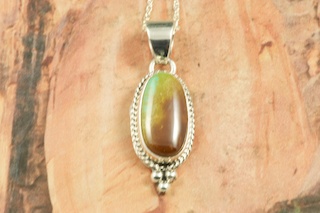 Genuine Royston Turquoise set in Sterling Silver Pendant. Beautiful Turquoise Stone. Created by Navajo Artist Lucy Valencia. Signed L. J. by the artist. Royston Turquoise Mine was originally known as the Royal Blue Mine. It produces Turquoise that has a mixture of blues and greens in the same formation. The Royston Turquoise Mine is located in Nye County, Nevada.  Free 18 inch Sterling Silver Chain with purchase of pendant.